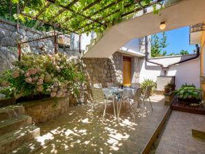 a patio with a table and chairs under a pergola at Apartment Sandalj-2 by Interhome in Kraj