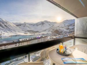 a room with a table and a view of mountains at Apartment Le Bec Rouge - Le Lac-2 by Interhome in Tignes