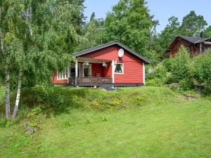 a red house on a hill with a yard at Chalet Västanvik Snickarhagen by Interhome in Motala