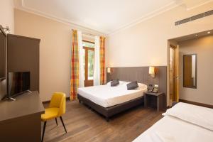 a bedroom with a bed and a yellow chair at Hotel Villa Betania in Florence