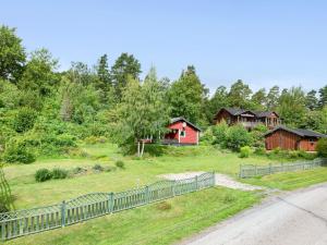 uma cerca em frente a um quintal com casas em Chalet Västanvik Snickarhagen - OST047 by Interhome em Motala