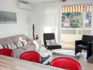 salon z kanapą i czerwonymi krzesłami w obiekcie Apartment Le Paradou by Interhome w mieście Virebelle