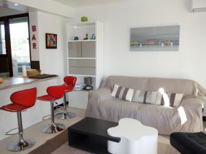 sala de estar con sofá y sillas rojas en Apartment Le Paradou by Interhome, en Virebelle