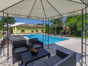 a patio with chairs and a swimming pool with a tent at Holiday Home Donada - LBN347 in Nedeščina