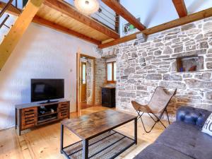 ein Wohnzimmer mit einem TV und einer Steinmauer in der Unterkunft Holiday Home Donada by Interhome in Nedeščina + 45 Fotos