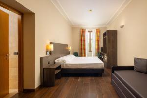 ein Schlafzimmer mit einem Bett und einem Sofa in der Unterkunft Hotel Villa Betania in Florenz