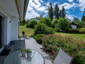 a patio with a table and chairs and flowers at Holiday Home Saarland by Interhome in Dittishausen