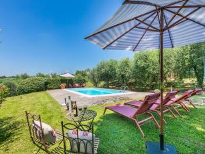 a group of chairs and an umbrella next to a swimming pool at Holiday Home Podere Cerbaia - SMR100 by Interhome in Santa Maria a Monte