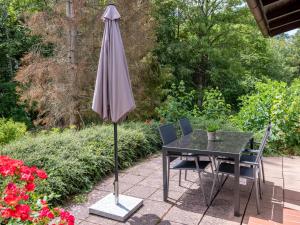 an umbrella sitting next to a table and chairs at Holiday Home Wanderlust by Interhome in Dittishausen