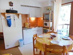 cocina con mesa y nevera blanca en Apartment La Borgia A- B- C-1 by Interhome, en Les Contamines-Montjoie