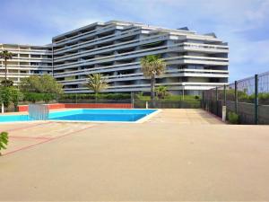 un gran edificio de apartamentos con piscina frente a él en Apartment Grand Sud-4 by Interhome, en Canet-en-Roussillon