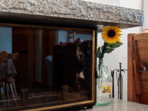 eine Vase mit Sonnenblume auf einem Tisch in der Unterkunft Apartment Apt-212X by Interhome in Veysonnaz