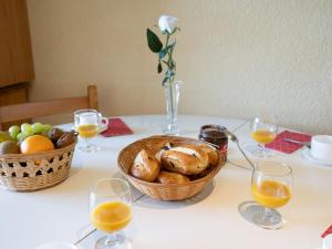 a table with a basket of bread and glasses of orange juice at Apartment Soyouz Vanguard-65 by Interhome in Le Corbier