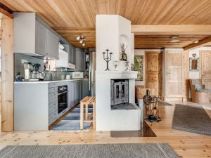 a kitchen with a fireplace and wooden ceilings at Chalet Fjällnäs by Interhome in Tänndalen