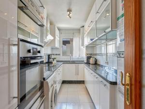 a large kitchen with white cabinets and appliances at Apartment Marina Bay-1 by Interhome in Estepona