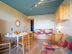 - un salon avec une table et un canapé dans l'établissement Apartment Soyouz Vanguard-65 by Interhome, au Corbier