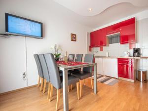 a dining room with a table with chairs and a kitchen at Apartment Markulin by Interhome in Rubeši