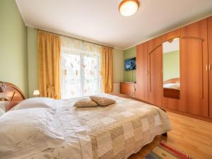 a bedroom with a large bed and a window at Apartment Markulin by Interhome in Rubeši