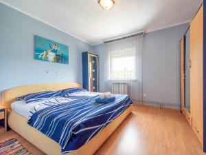 a bedroom with a bed with blue walls at Apartment Markulin by Interhome in Rubeši