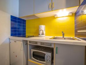 a small kitchen with a sink and a microwave at Apartment Tahiti by Interhome in La Grande Motte