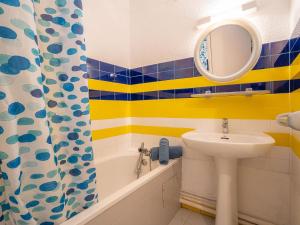 a bathroom with a sink and a mirror and a tub at Apartment Tahiti by Interhome in La Grande Motte