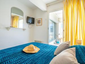 um chapéu sentado numa cama num quarto em Apartment Cap Sud-3 by Interhome em Canet-en-Roussillon