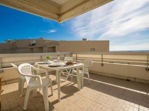 een witte tafel en stoelen op een balkon bij Apartment Cap Sud-3 by Interhome in Canet-en-Roussillon