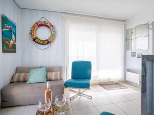 een woonkamer met een bank en een blauwe stoel bij Apartment Cap Sud-3 by Interhome in Canet-en-Roussillon
