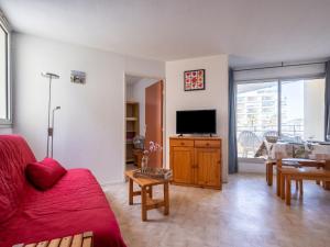 - un salon avec un canapé rouge et une télévision dans l'établissement Apartment Le Beach-14 by Interhome, à Canet