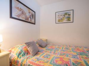 a bedroom with a bed with a colorful quilt at Apartment Le Sunset-Cap Sud-1 by Interhome in Cap d'Agde