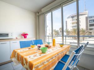 a dining room with a table and chairs and a window at Apartment Le Sunset-Cap Sud-1 by Interhome in Cap d'Agde