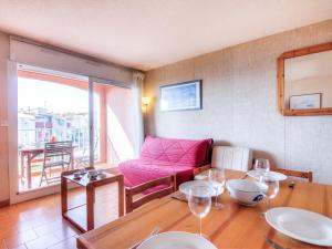 a living room with a table and a pink chair at Apartment Les Indes Galantes by Interhome in Cap d'Agde