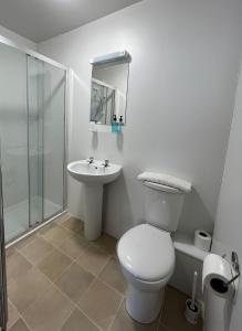 a white bathroom with a toilet and a sink at The Kelvin Hotel in Oban