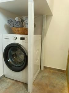a washer and dryer in a laundry room with a shelf at Domek letniskowy na Kaszubach, Borowy Młyn, jezioro Gwiazda in Borowy Młyn
