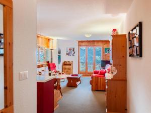 eine Küche und ein Wohnzimmer mit roten Möbeln in einem Haus in der Unterkunft Apartment Les Crêtes 1-3 by Interhome in Veysonnaz