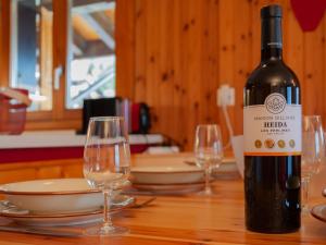 a bottle of wine sitting on a table with two glasses at Apartment Les Crêtes 1-3 by Interhome in Veysonnaz +28 photos