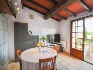 uma sala de jantar com uma mesa e uma cozinha em Apartment les Oiseaux by Interhome em Cavalaire-sur-Mer