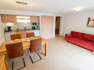 a living room with a table and a red couch at Holiday Home Romeo by Interhome in Dittishausen