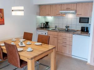 a kitchen with a wooden table with chairs and a sink at Holiday Home Romeo by Interhome in Dittishausen