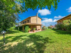 a house in a yard with a green lawn at Holiday Home Poggio al Colle by Interhome in San Vivaldo