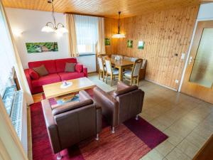 a living room with a red couch and a table at Holiday Home Romeo by Interhome in Dittishausen