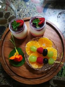 three desserts on a wooden plate with fruit on it at Bronberg Bastion in Tierpoort