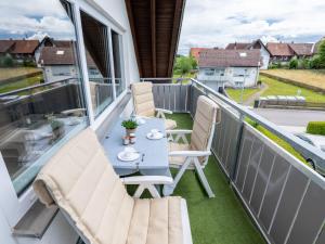 einen Balkon mit einem Tisch und Stühlen darauf in der Unterkunft Apartment Hochfirst by Interhome in Dittishausen