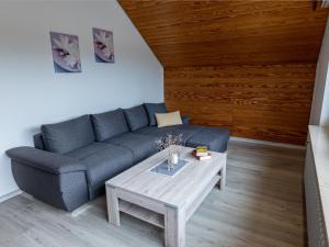 ein Wohnzimmer mit einem blauen Sofa und einem Couchtisch in der Unterkunft Apartment Hochfirst by Interhome in Dittishausen