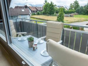 una mesa y sillas en un balcón con vistas en Apartment Hochfirst by Interhome en Dittishausen
