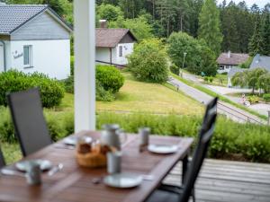 - une table en bois sur une terrasse couverte avec vue sur la cour dans l'établissement Holiday Home Ambiente by Interhome, à Dittishausen