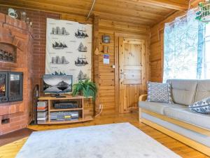 a living room with a couch and a tv at Holiday Home Tuomola by Interhome in Lappajärvi