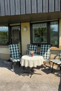un patio con 2 sillas y una mesa con flores. en Apartment Schwarzwaldblick-14 by Interhome, en Schonach