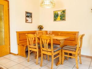 ein Esszimmer mit einem Holztisch und Stühlen in der Unterkunft Holiday Home Vergissmeinnicht by Interhome in Dittishausen