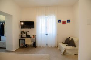CALLIA ROOMS PROCIDA في بروسيدا: غرفة معيشة بيضاء مع أريكة ومكتب